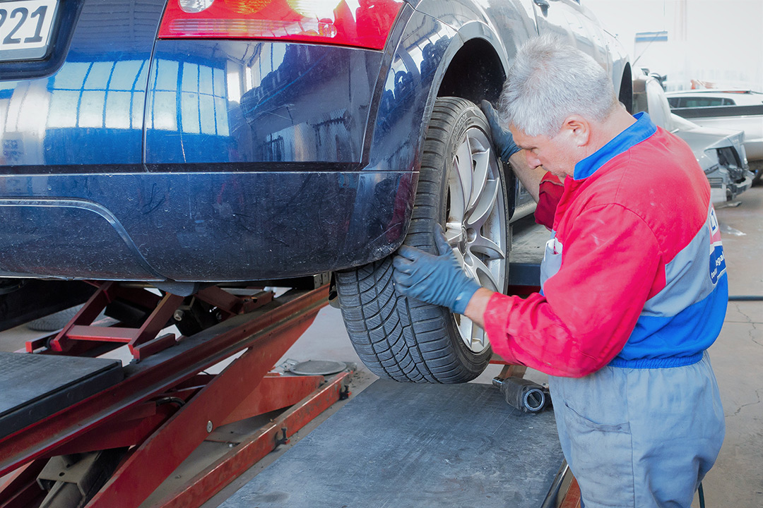 Mechanic examining a car tyre in a garage